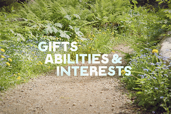 Close-up of a garden path lined with green ferns and wildflowers