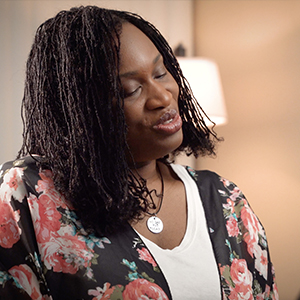 Portrait of Morénike Giwa Onaiwu speaking, wearing a floral top and silver necklace